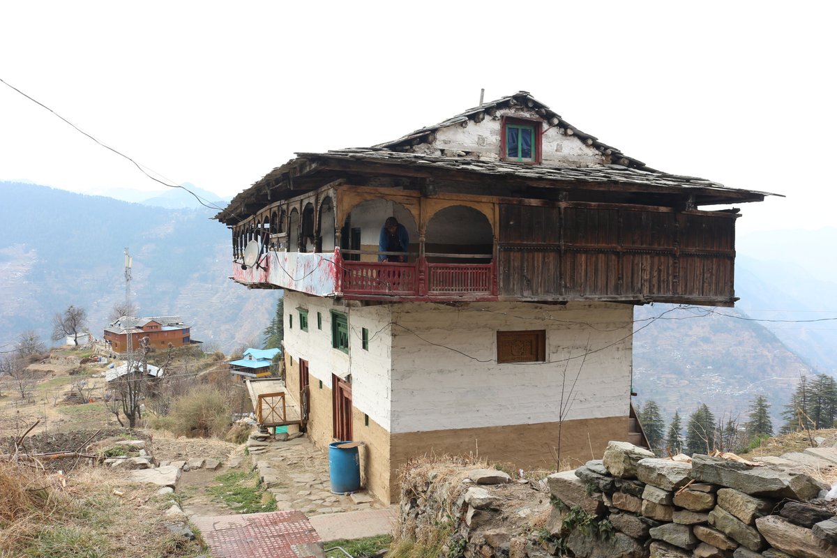 A traditional kath-kuni house with stone walls, wooden balcony and slate roof