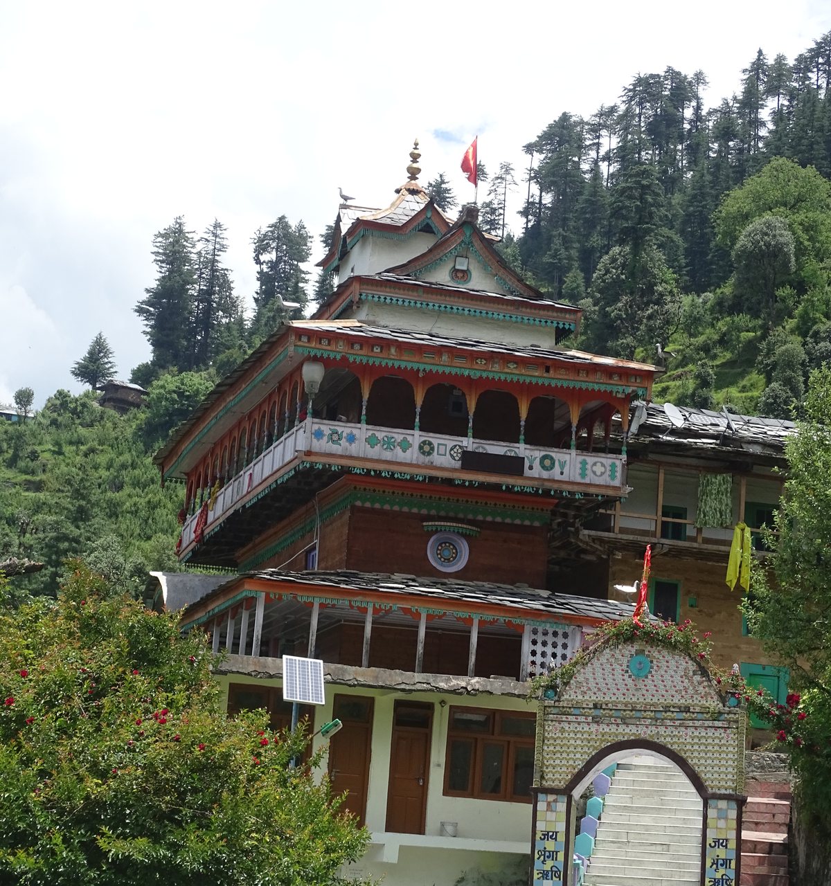 The Shringa Rishi temple with tiered roofs, carved wooden balconies and a painted gate